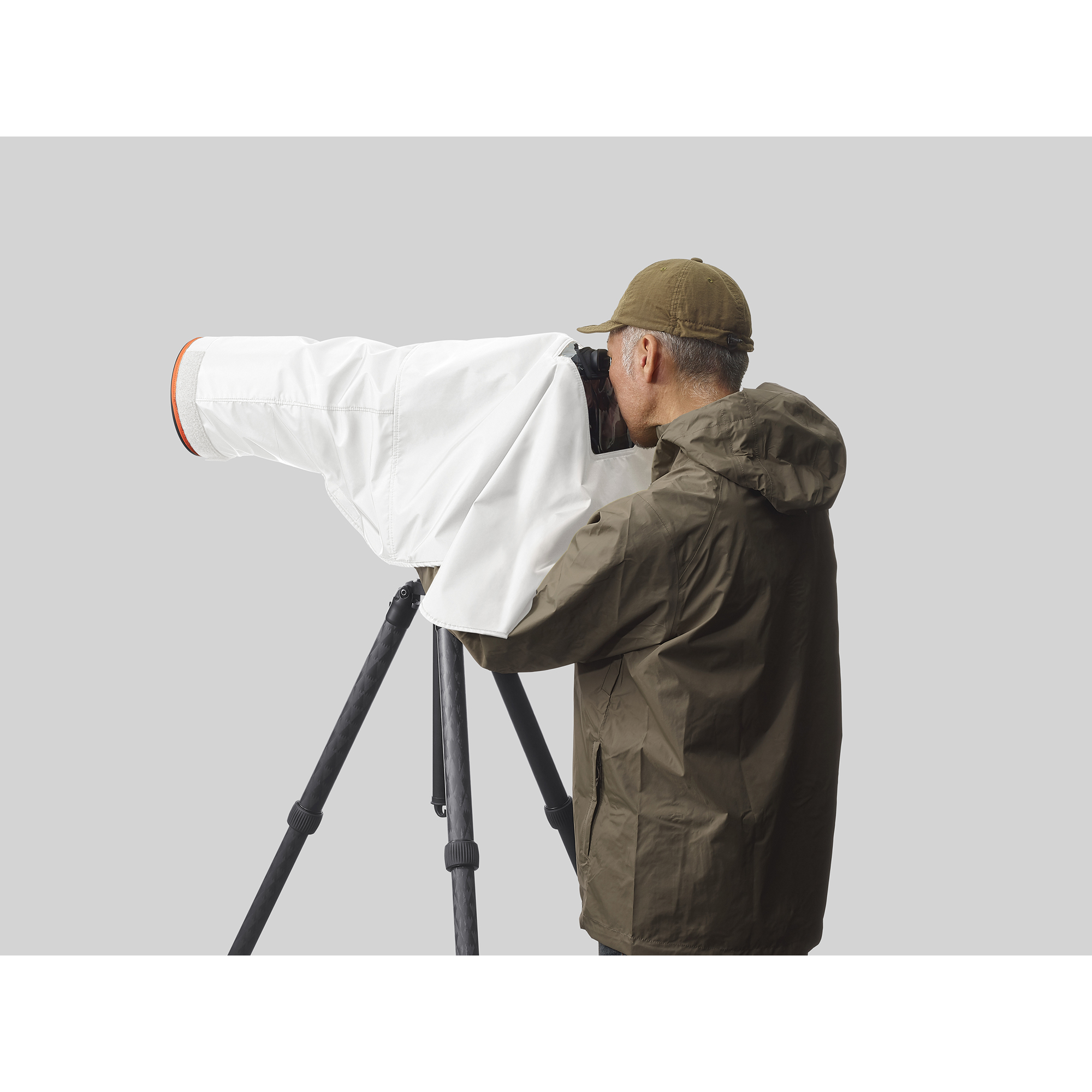 一位攝影師正在拍攝， Sony 相機套上白色防雨罩，相機架在腳架上情境圖