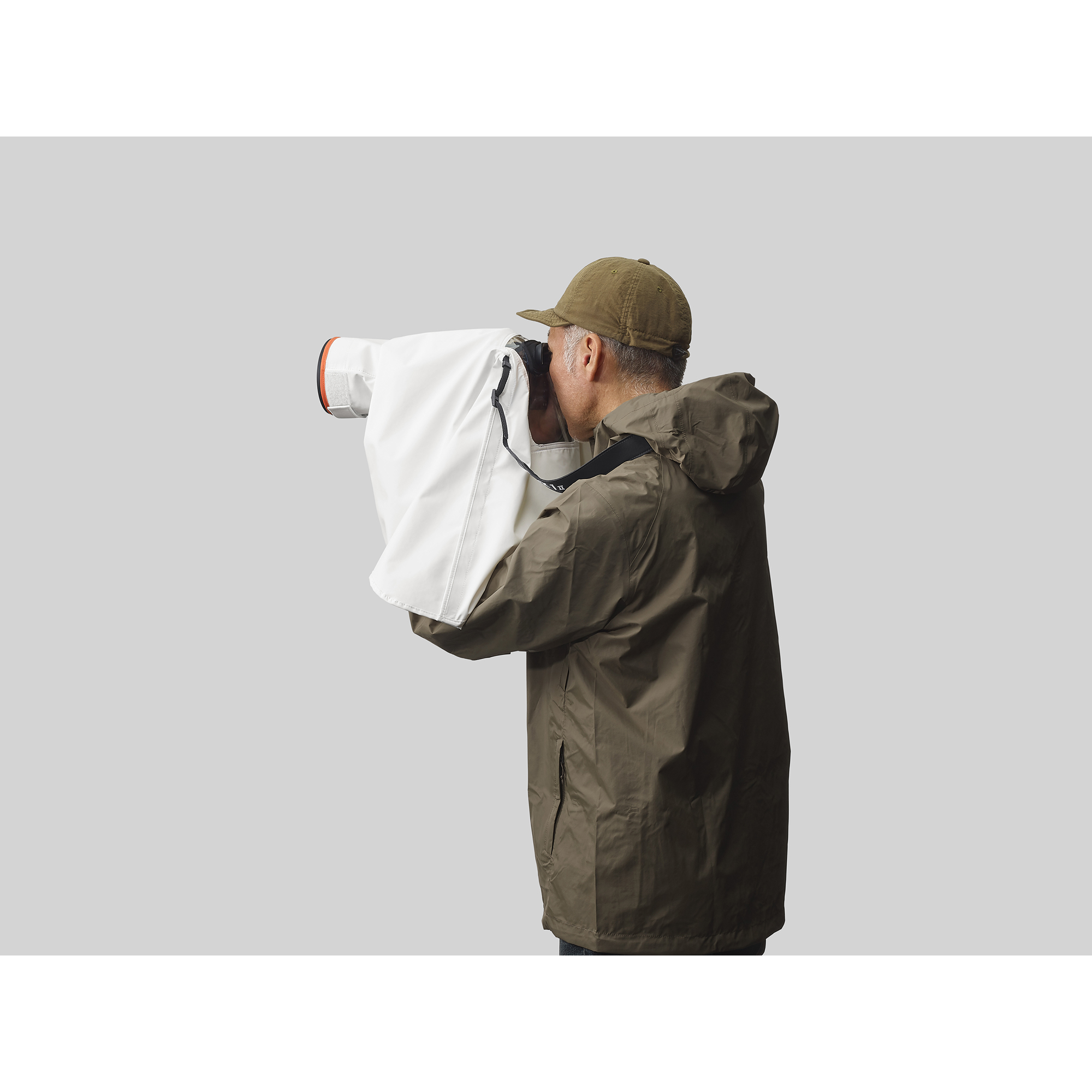 一位攝影師正在拍攝， Sony 相機套上白色防雨罩，相機架在腳架上情境圖