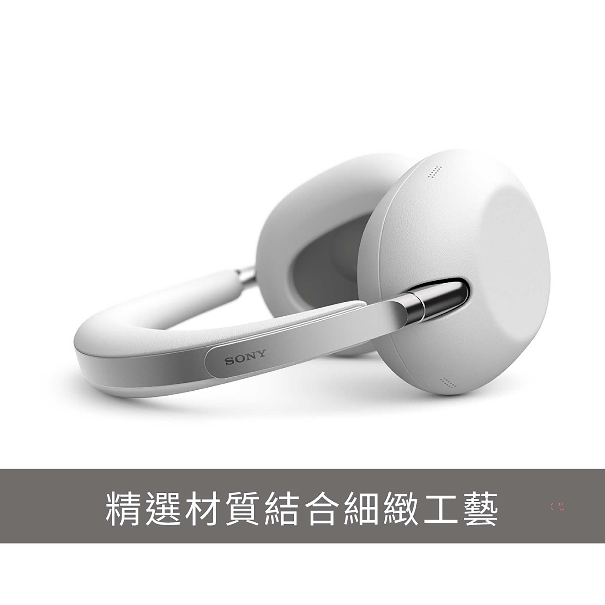 白色 1000X THE COLLEXION 耳機平放在地上，頭帶貼地擺放，背景為白色